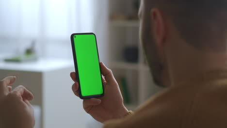 Kommunikation-Per-App-Im-Smartphone-Videoanruf-Auf-Grünem-Bildschirm.-Mann-Spricht-Und-Schaut-Auf-Das-Display,-Nahaufnahme-Des-Gadgets